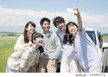 車の周りで写真を撮る大学生 車の周りで写真を撮る大学生 25095771