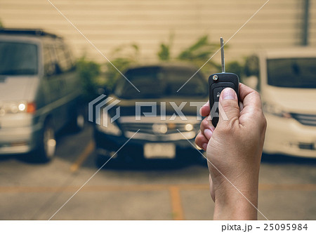 Hand holding and touching the keys over photo blurred of used car for open the door car, transportation and ownership concept Hand holding and touching the keys over photo blurred of used car for open the door car, transportation and ownership concept 25095984