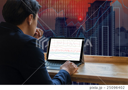 Businessman sitting and using computer laptop showing trading graph beside the windows glass over the Trading graph on the cityscape background, Business financial concept 25096402