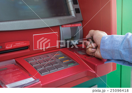 Closeup of male hands using and with insert ATM card into bank machine for withdraw the money, business technology banking concept 25096418