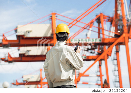 埠頭のガトリングクレーンと港湾作業員 25132204