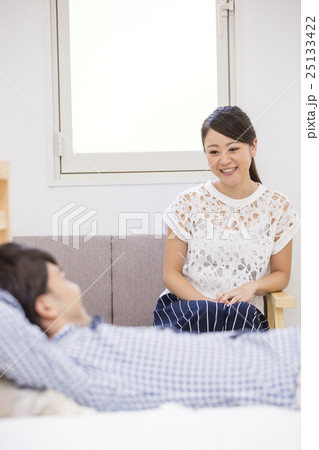 ベッドに入る男性とソファに座る女性 ベッドに入る男性とソファに座る女性 25133422