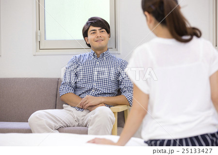 ソファに座る男性とベッドに座る女性 ソファに座る男性とベッドに座る女性 25133427