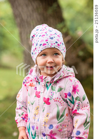 The little baby girl standing at park 25136089
