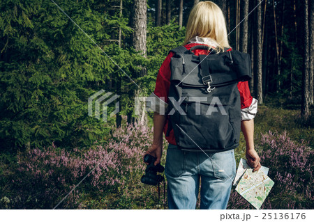 Young active woman tourist standing in a clearing 25136176