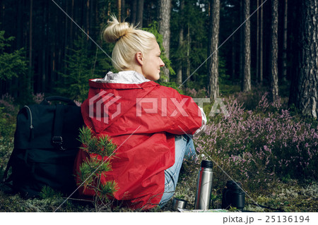 Young active woman tourist sitting in a clearing Young active woman tourist sitting in a clearing 25136194