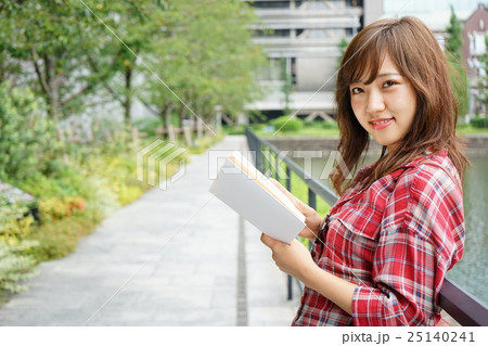 外で読書をする若い日本人の女性 25140241