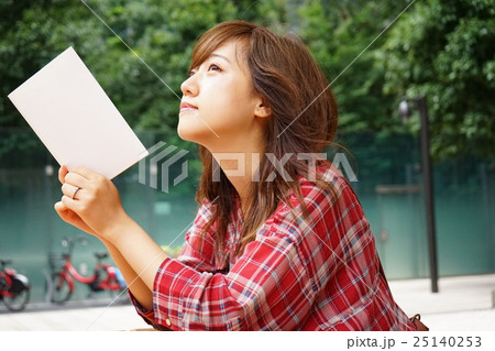 外で読書をする若い日本人の女性 25140253