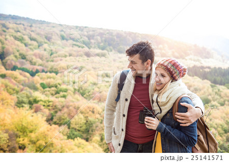 Young couple on a walk in sunny autumn forest Young couple on a walk in sunny autumn forest 25141571