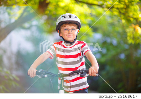 Preschool kid boy in helmet having fun with riding Preschool kid boy in helmet having fun with riding 25168617