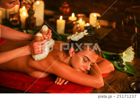 Young woman have hot poultice massage in spa salon 25171237