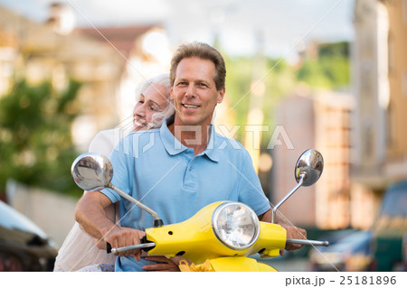 Man with woman on scooter. 25181896