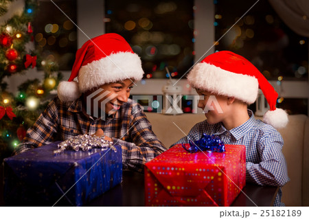 Two kids near Christmas presents. 25182189