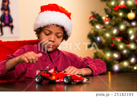 Kid playing with Christmas present. Kid playing with Christmas present. 25182193