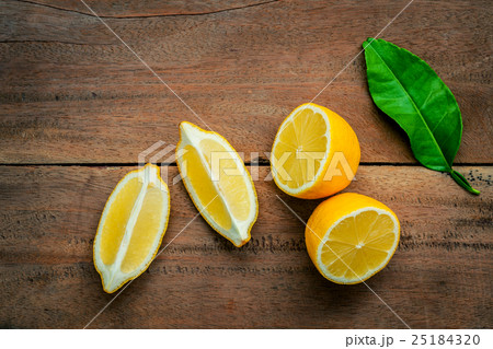 Fresh lemons and lemons leaves on rustic wooden . Fresh lemons and lemons leaves on rustic wooden . 25184320