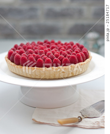 Raspberry tart on a white plate Selective focus 25184717