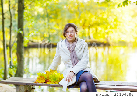Happy young woman with autumn maple leaves garland Happy young woman with autumn maple leaves garland 25194986