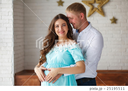 Pregnant woman and her husband touching belly with 25195511