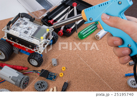 Hand holding soldering iron tool assembling robot. Hand holding soldering iron tool assembling robot. 25195740