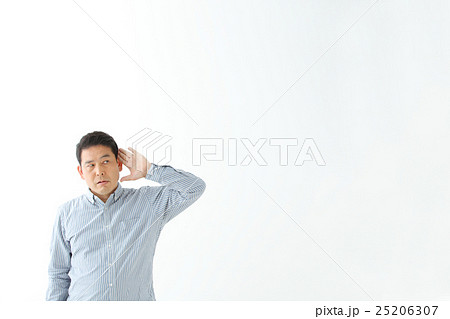 耳に手を添える男性の写真素材