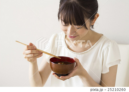 豆腐のみそ汁を飲む女性の写真素材