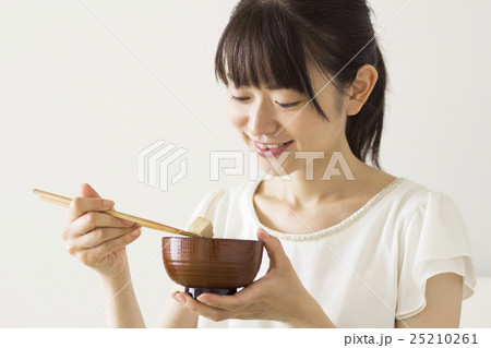 豆腐のみそ汁を飲む女性の写真素材