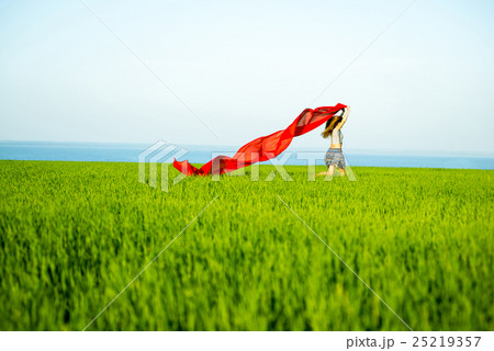 Young happy woman in wheat field with fabric 25219357