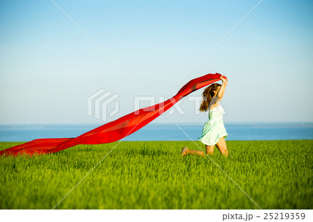 Young happy woman in wheat field with fabric 25219359