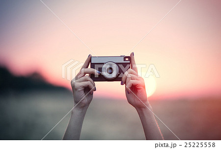 hands holding a camera 25225558