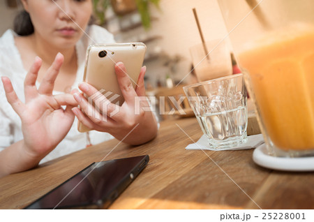 Woman using phone in cafe 25228001