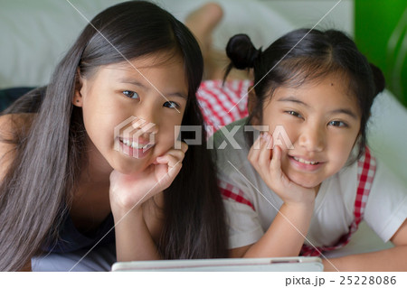 Close up of Asian child using tablet together 25228086