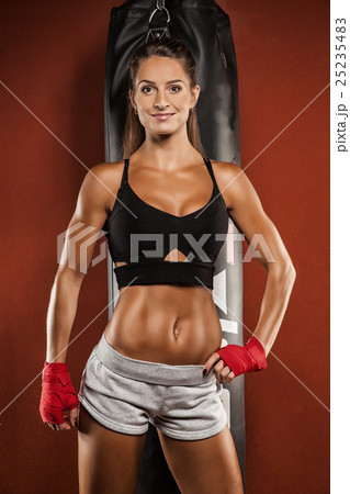 Young woman making a hard punch on a punching bag Young woman making a hard punch on a punching bag 25235483