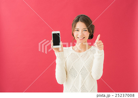 スマホを操作する女性(赤背景) スマホを操作する女性(赤背景) 25237008