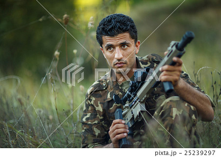 Man of Arab nationality in camouflage with a gun 25239297