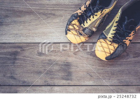 Old football shoes on grey wooden plank Old football shoes on grey wooden plank 25248732