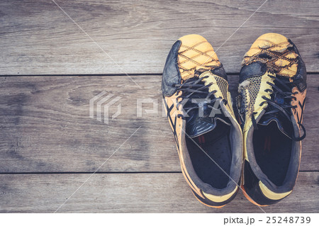 Old football shoes on grey wooden plank Old football shoes on grey wooden plank 25248739