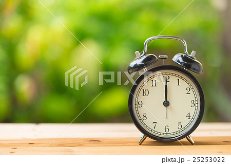 retro clock in green garden at 12 o'clock 25253022