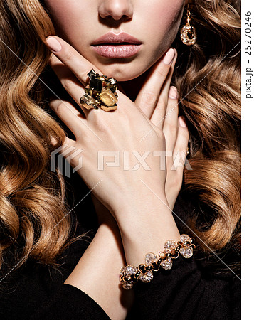Face of  woman with long hair and gold jewelry 25270246