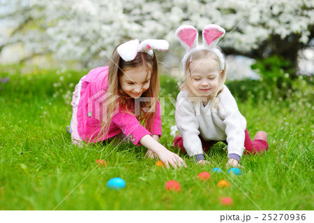 Two little sisters hunting for easter egg on Easter day Two little sisters hunting for easter egg on Easter day 25270936