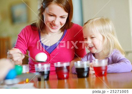 Young mother and her daughter painting Easter eggs Young mother and her daughter painting Easter eggs 25271005
