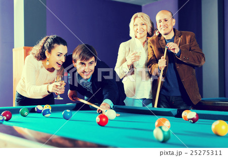 Group of friends playing billiards Group of friends playing billiards 25275311