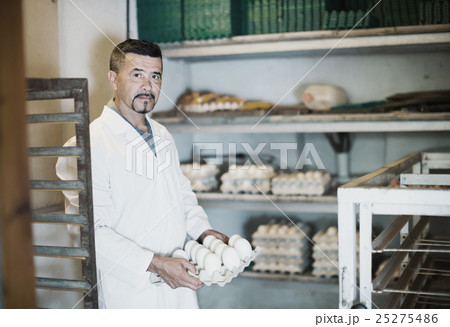 Glad man working and packing white hen eggs 25275486