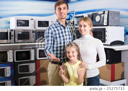 Positive couple with kid in store with electronics Positive couple with kid in store with electronics 25275732