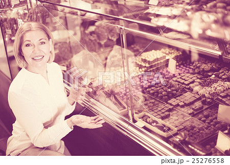 Happy blonde pensioner buying chocolate 25276558