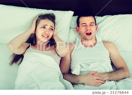 Young woman disturbed with partner snores . Young woman disturbed with partner snores . 25276644