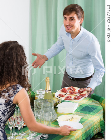 Young couple serving table at home . Young couple serving table at home . 25277313