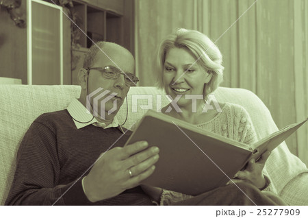 Smiling pensioners watching old photoes Smiling pensioners watching old photoes 25277909