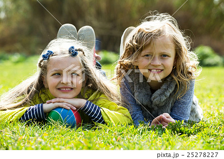 Junior school aged girls lying on grass Junior school aged girls lying on grass 25278227