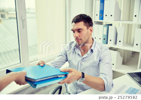 businessman taking folder from secretary in office businessman taking folder from secretary in office 25279582