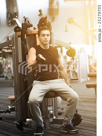 man exercising on gym machine 25279705